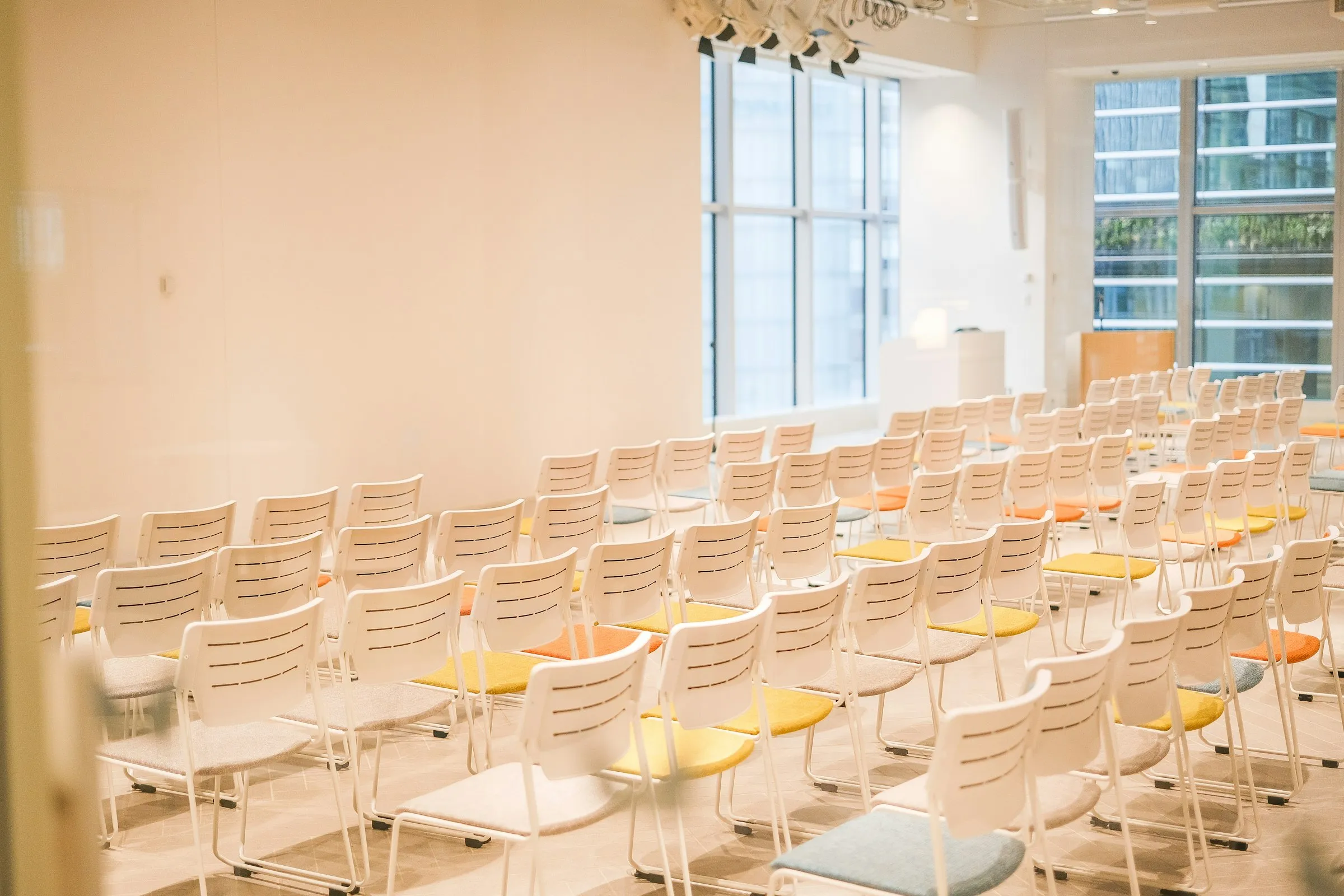 Rows of chairs facing a lectern in a bright seminar room